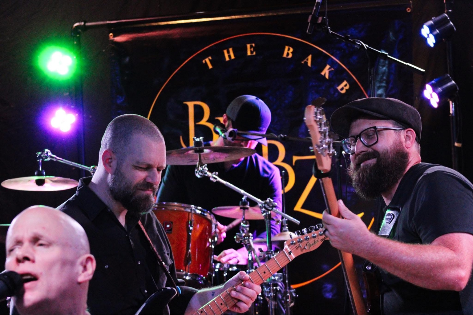 The BakBeatz guitar, bass and drums locked in on stage